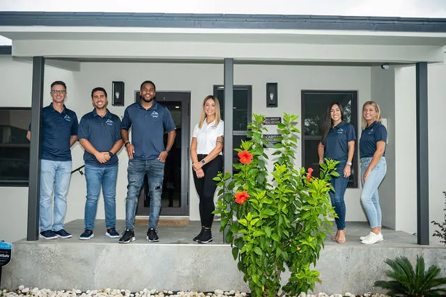 All About Real Estate team in front of a renovated South Florida home