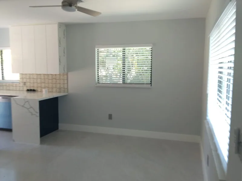 After: the same Miami duplex kitchen renovated with navy cabinets and new flooring