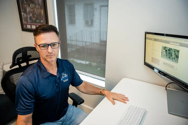 Petru Pusta, founder of All About Real Estate, reviewing property records at the Hollywood, FL office